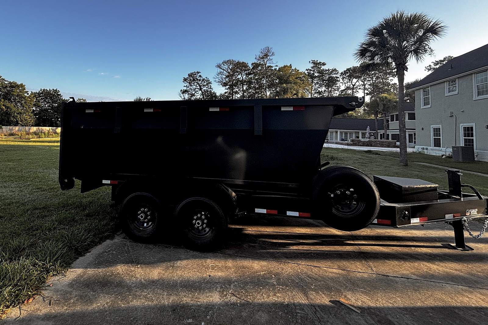 Side profile of the roll-off container showing the full length and rear barn doors.